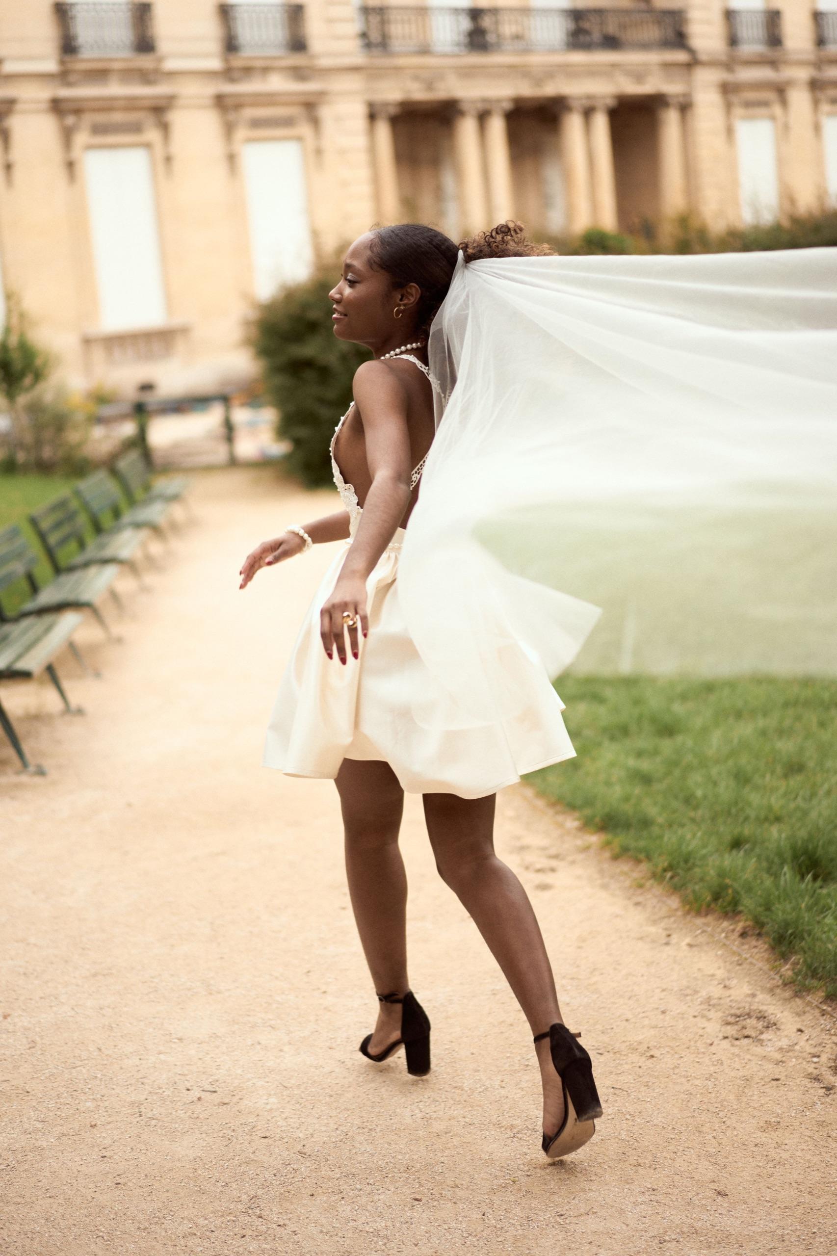 Une mariée virevoltant dans une robe courte et un long voile